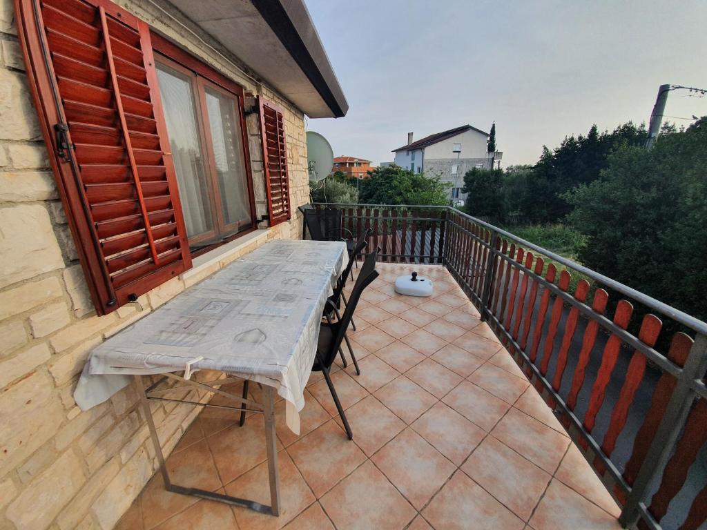eine Terrasse mit Tisch und Stühlen auf einem Balkon in der Unterkunft Anja in Umag