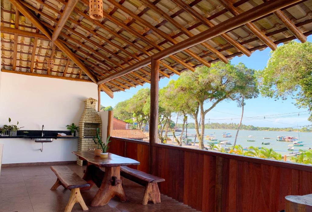 un patio con mesa y vistas al agua en Villa Palmeira, en Itacaré