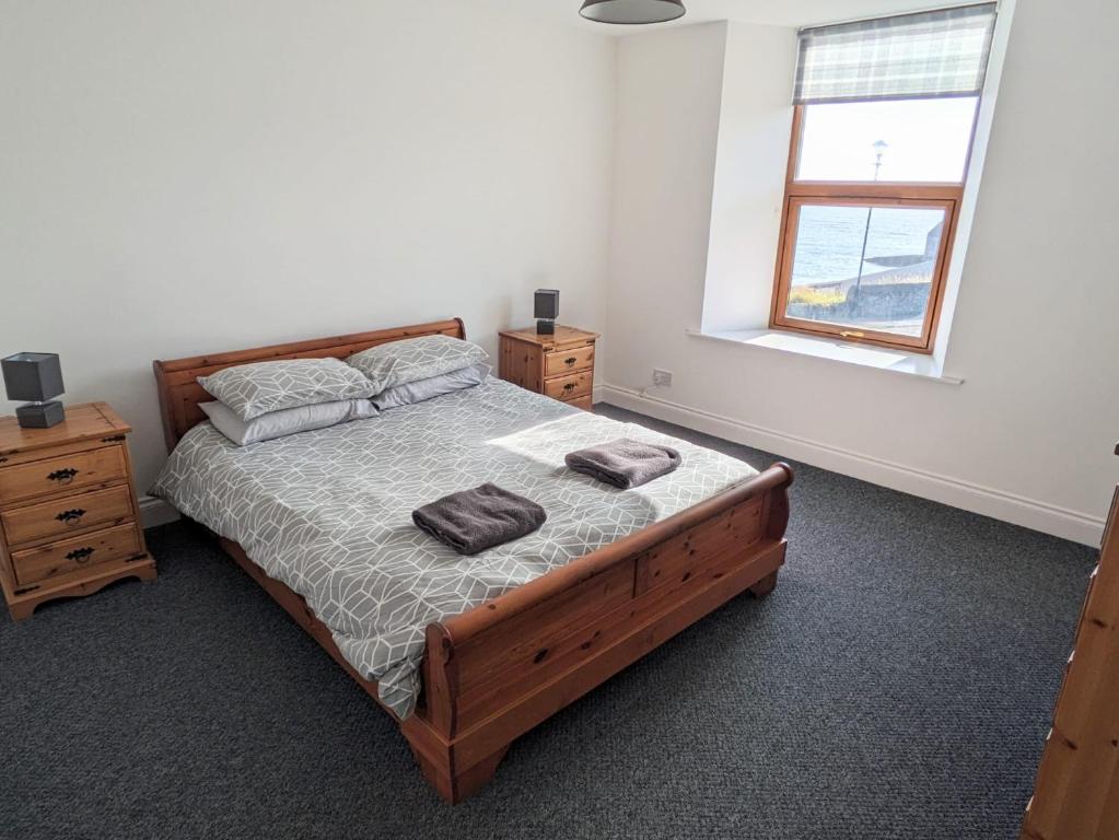 1 dormitorio con 1 cama con 2 toallas en 2 Bedroom Townhouse with Seaview on the NC500 Wick, en Wick