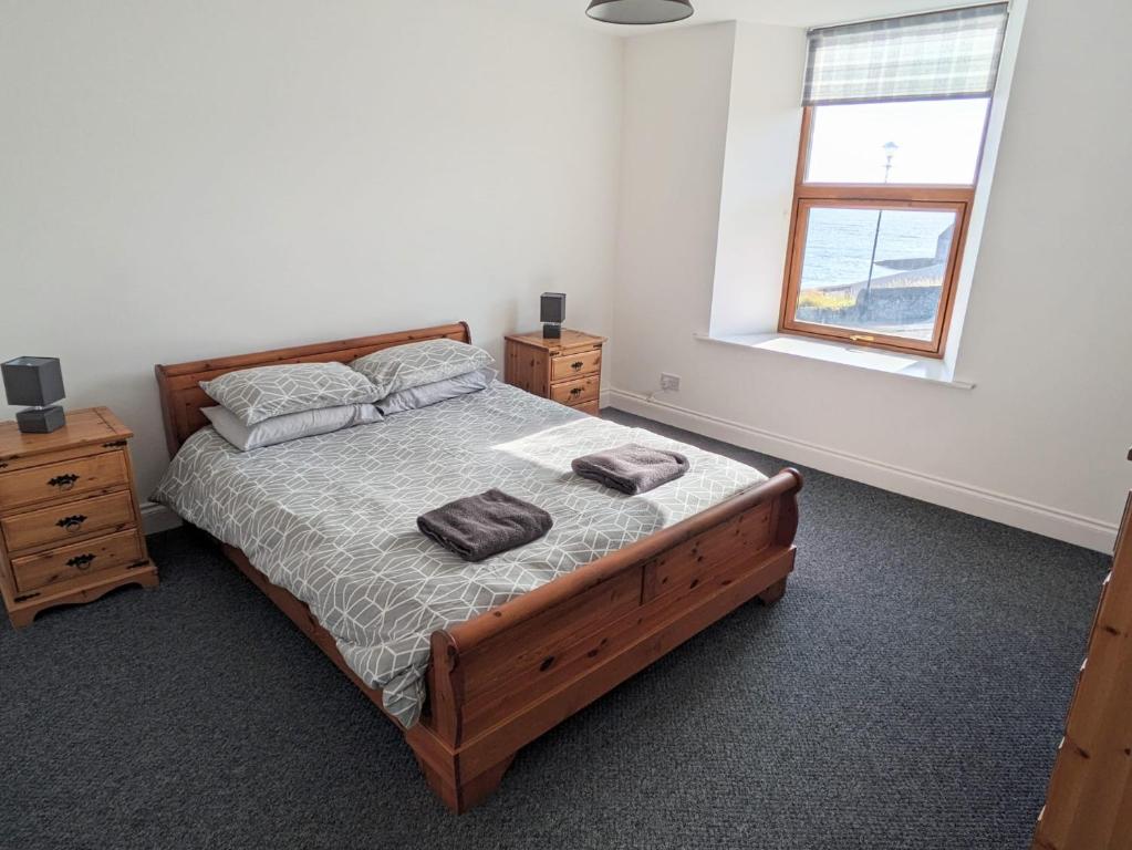 ウィックにある2 Bedroom Townhouse with Seaview on the NC500 Wickのベッドとタオル2枚のある寝室