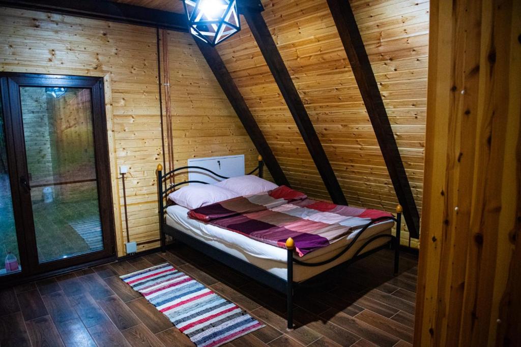 1 dormitorio con 1 cama en una cabaña de madera en Cabana Arunia, 