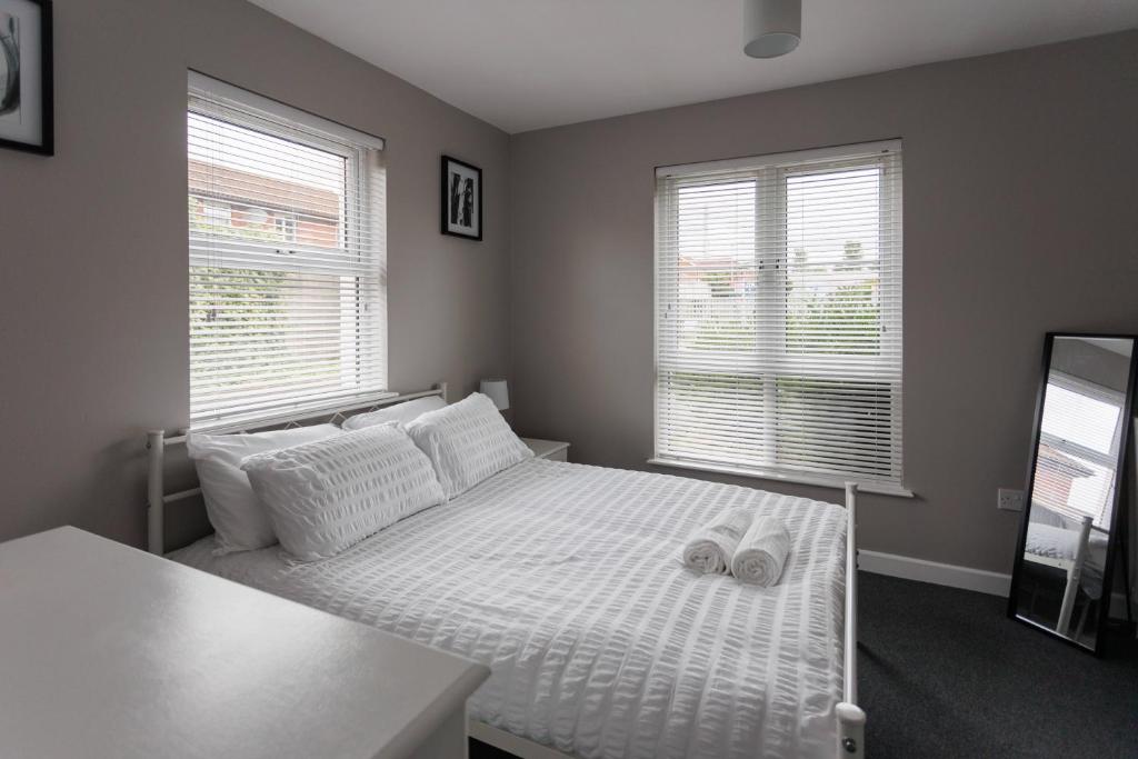 a bedroom with a white bed with two white pillows at Apartment 4 Oak Villa in Belfast