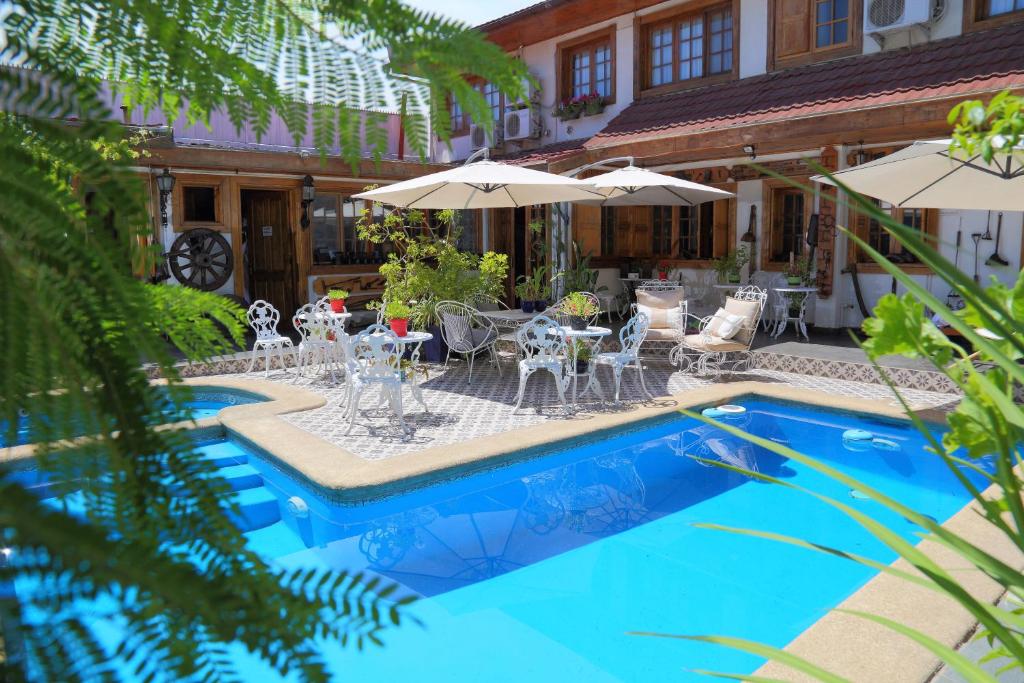 een zwembad met tafels, stoelen en parasols bij Hotel Boutique Vendimia Premium in Santa Cruz