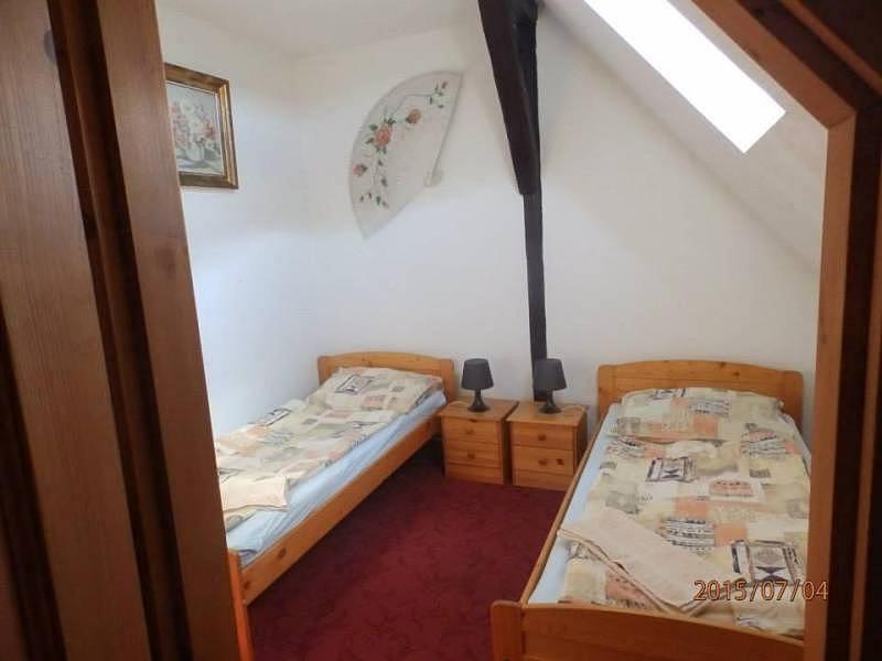 two twin beds in a room with a attic at Chalupa pod sjezdovkou in Chvaleč