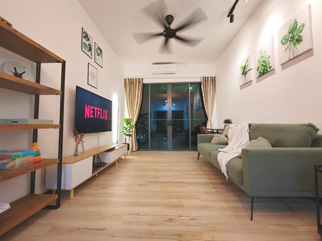 a living room with a green couch and a ceiling fan at Monstera Meritus Homestay - Penang Butterworth Prai 1-8PAX in Perai