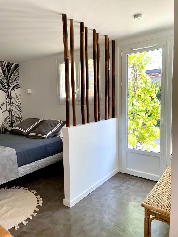 een slaapkamer met een bed en een raam bij Les Pinsons studio in La Ciotat