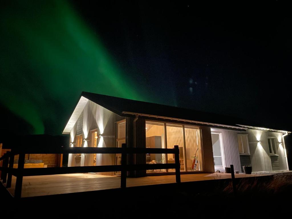 a house with the green northern lights in the sky at Fjallagil in Varmahlid