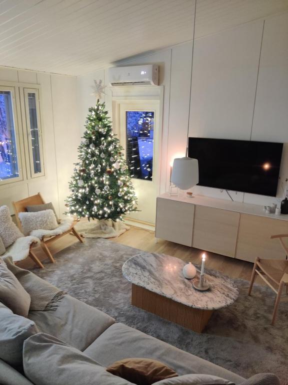 a living room with a christmas tree and a couch at Sunstar Villa in Rovaniemi