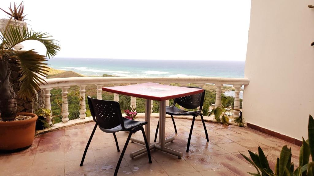 een tafel en 2 stoelen op een balkon met uitzicht op de oceaan bij Best ocean view 1 bedroom long term opportunity in Las Flores