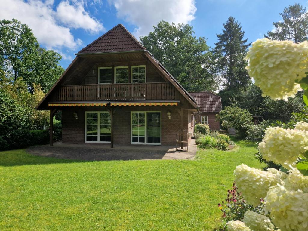 ein Haus mit einem grünen Hof mit einem Haus in der Unterkunft Ferienhuus Bossel in Bispingen