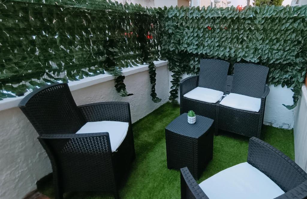 two chairs and a table on a patio with plants at Savoia23 - Luxury Superior Suite - in Nardò