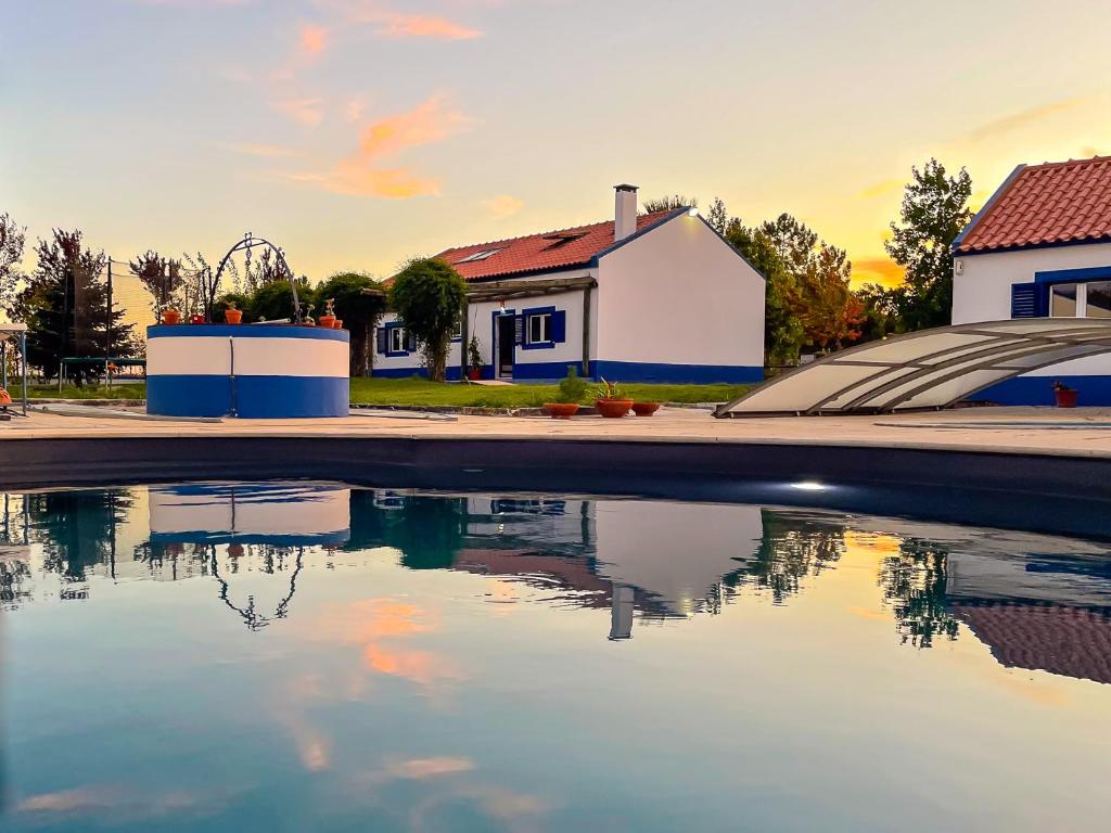una piscina de agua frente a una casa en Quinta do Cutato - Beatriz Guest House - A2 en Santo Estêvão