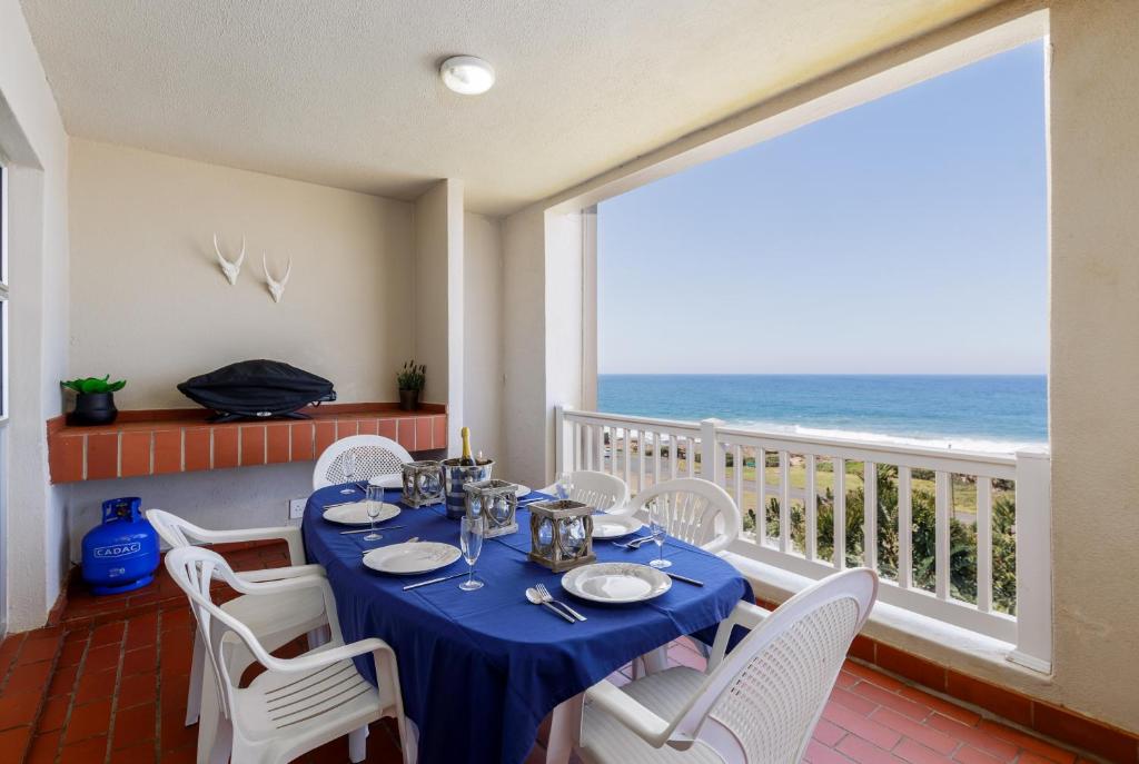 een eetkamer met een tafel en uitzicht op de oceaan bij Laguna La Crete 9 in Uvongo Beach