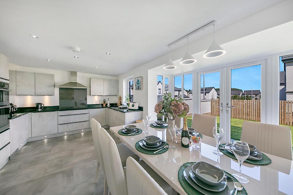 uma cozinha e sala de jantar com mesa e cadeiras em Fern Place Villa - Grampian Lettings Ltd 