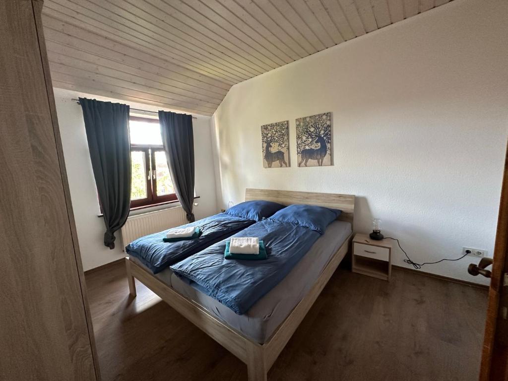 1 dormitorio con cama con sábanas azules y ventana en 98qm Wohnung im Villenviertel - Voll ausgestattet mit Balkon und Kamin - WLAN gratis, en Wilhelmshaven