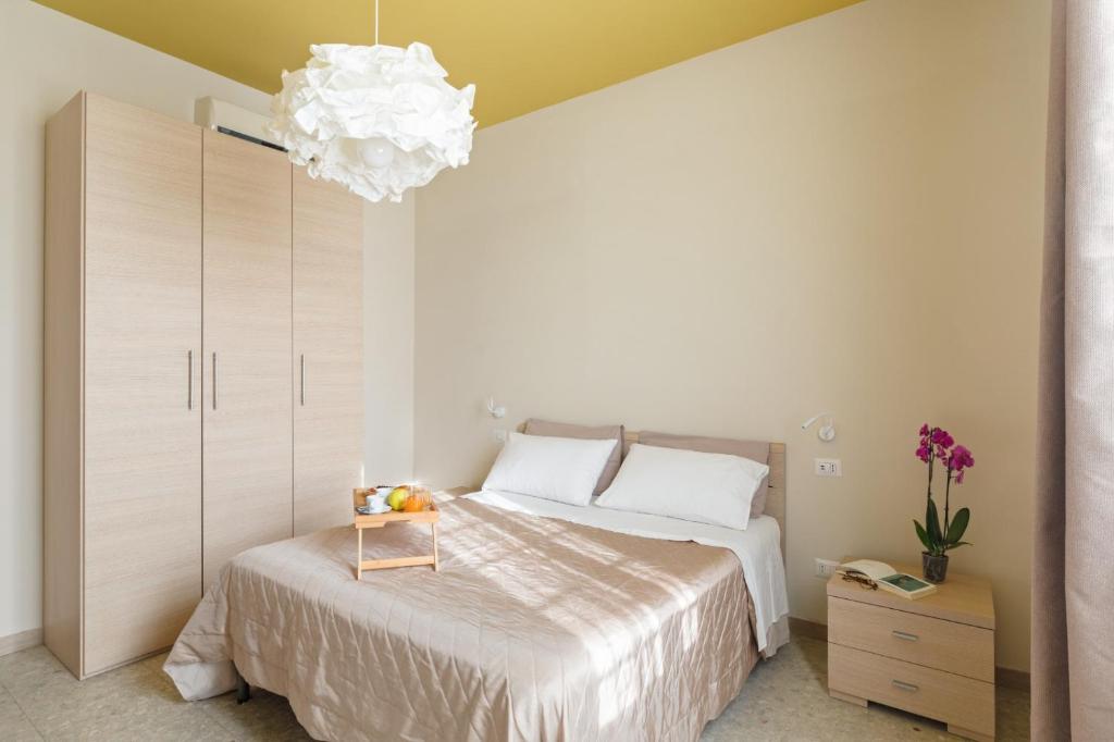 a bedroom with a large bed and a chandelier at B&B L'Amaca in Rome