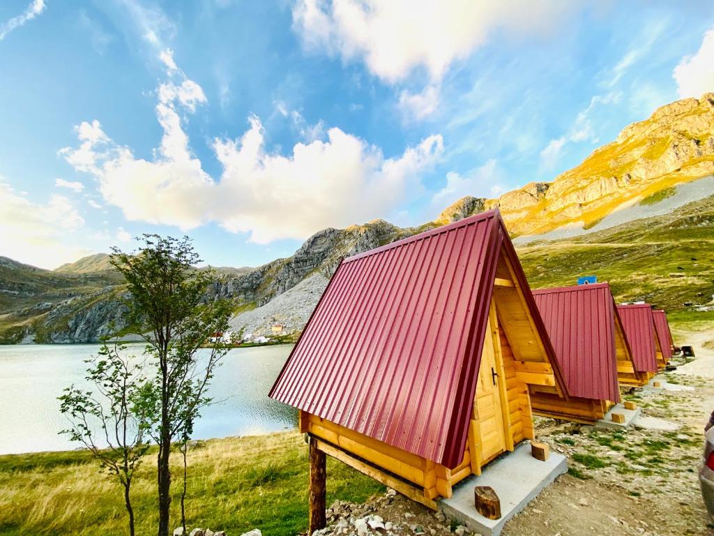 uma fileira de cabanas numa colina junto a um lago em Rural Household MINIĆ - Kapetanovo jezero em Kolašin