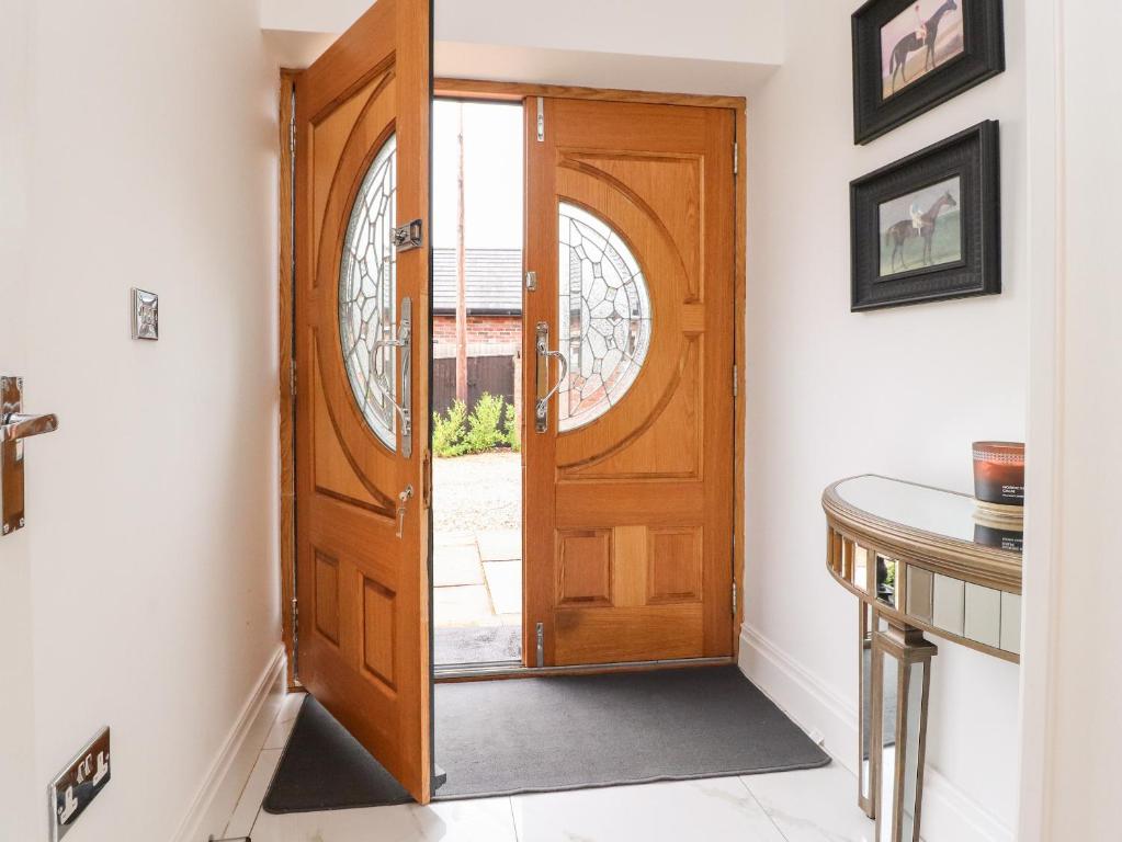 a wooden door in a room with a table at Damson Cottage in Poulton le Fylde