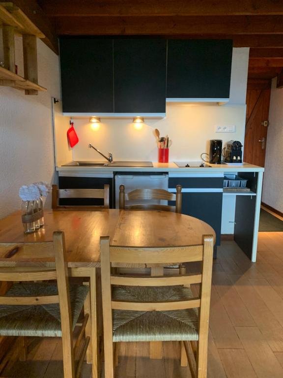 cocina con mesa de madera con sillas y encimeras de cocina en Pyrénées 2000 chalet 4 pers., en Bolquere Pyrenees 2000