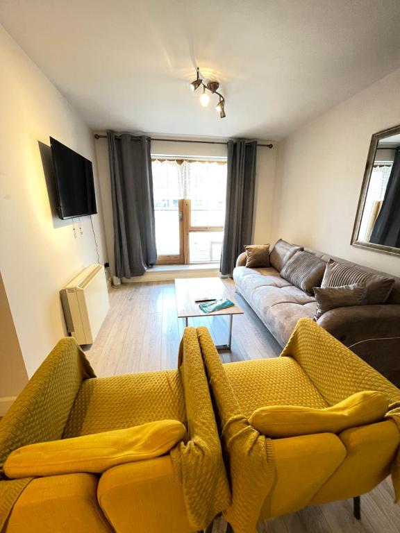 a living room with a couch and a yellow blanket at Greeg Court in Dublin