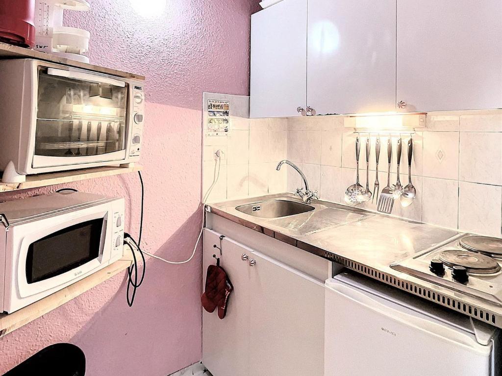 a small kitchen with a microwave and a sink at Studio Le Corbier, 1 pièce, 5 personnes - FR-1-267-232 in Villarembert