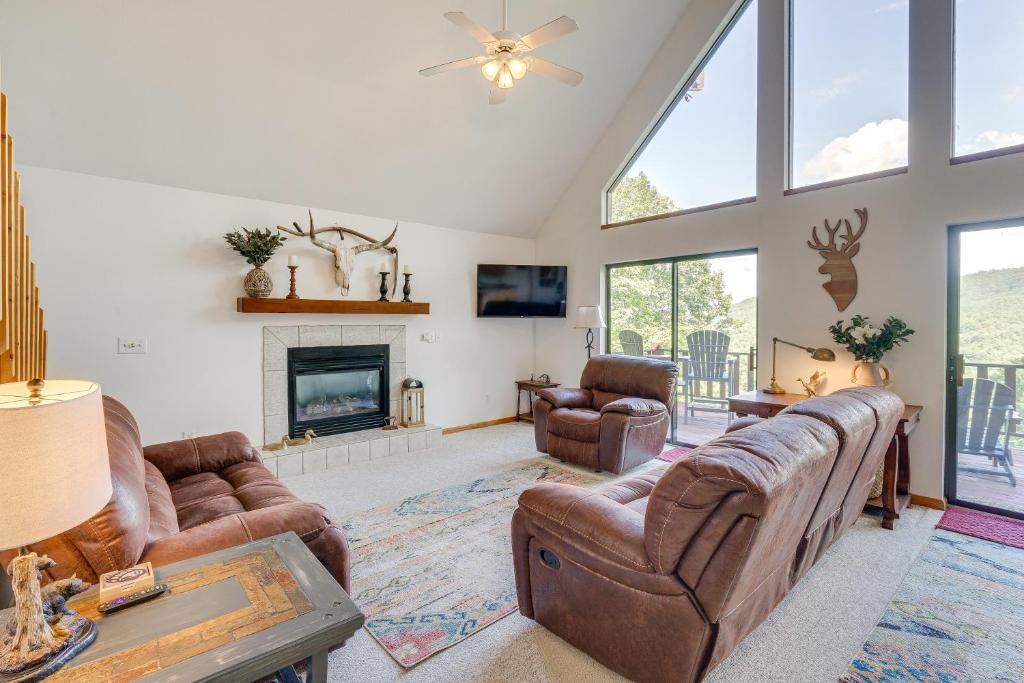 uma sala de estar com mobiliário de couro e uma lareira em Murphy Cabin with Deck and Sweeping Mountain Views! em Murphy