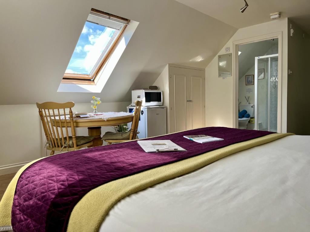 a bedroom with a bed and a table and a window at Priors Oak - A Cosy Studio with Countryside Views in Dorset in Stalbridge