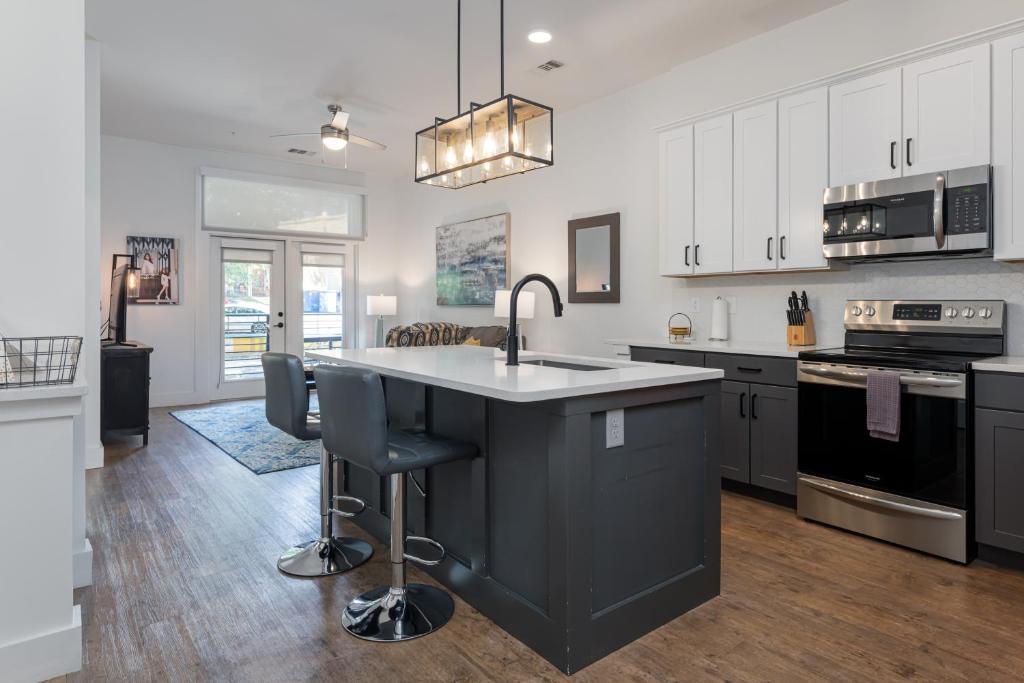 a kitchen with white cabinets and a black island at 55 South Market Condo 214 in Asheville