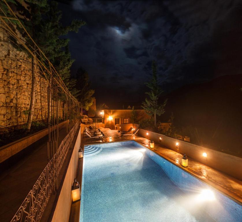 uma piscina à noite com luzes laterais em Auberge Chez Pierre em Boumalne