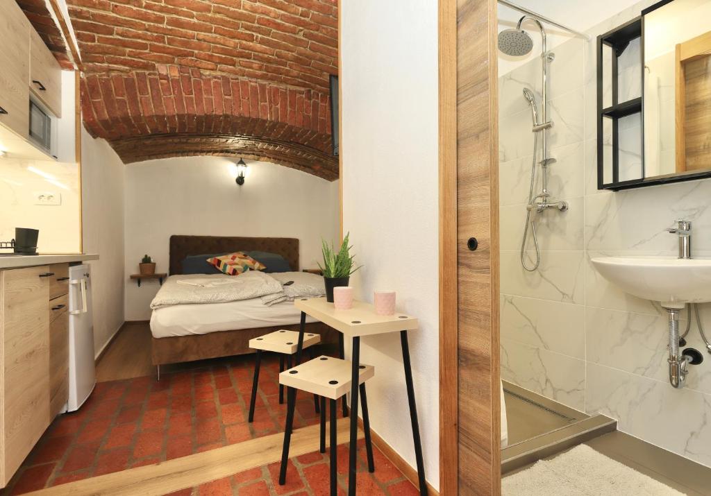 a bathroom with a bed and a sink and a shower at Podroom Apartments in Ljubljana