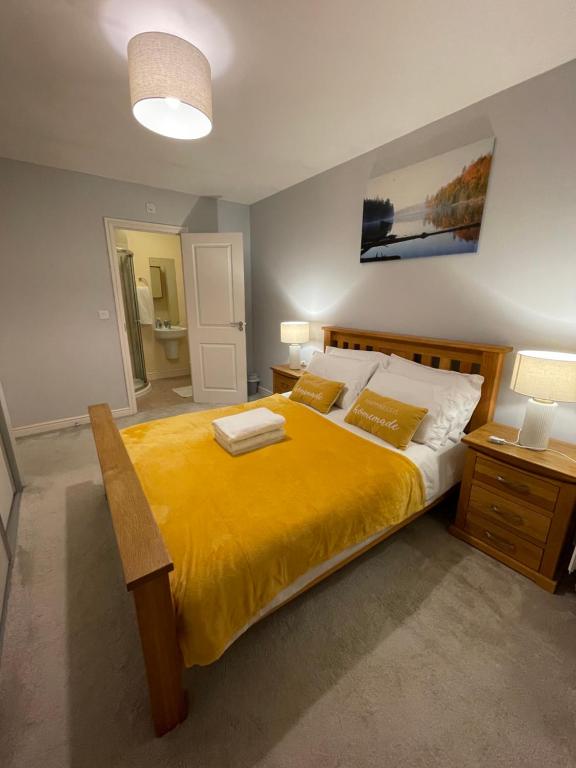 a bedroom with a large bed with a yellow blanket at Holiday Home In Cardiff, Sleeps 8 in Cardiff