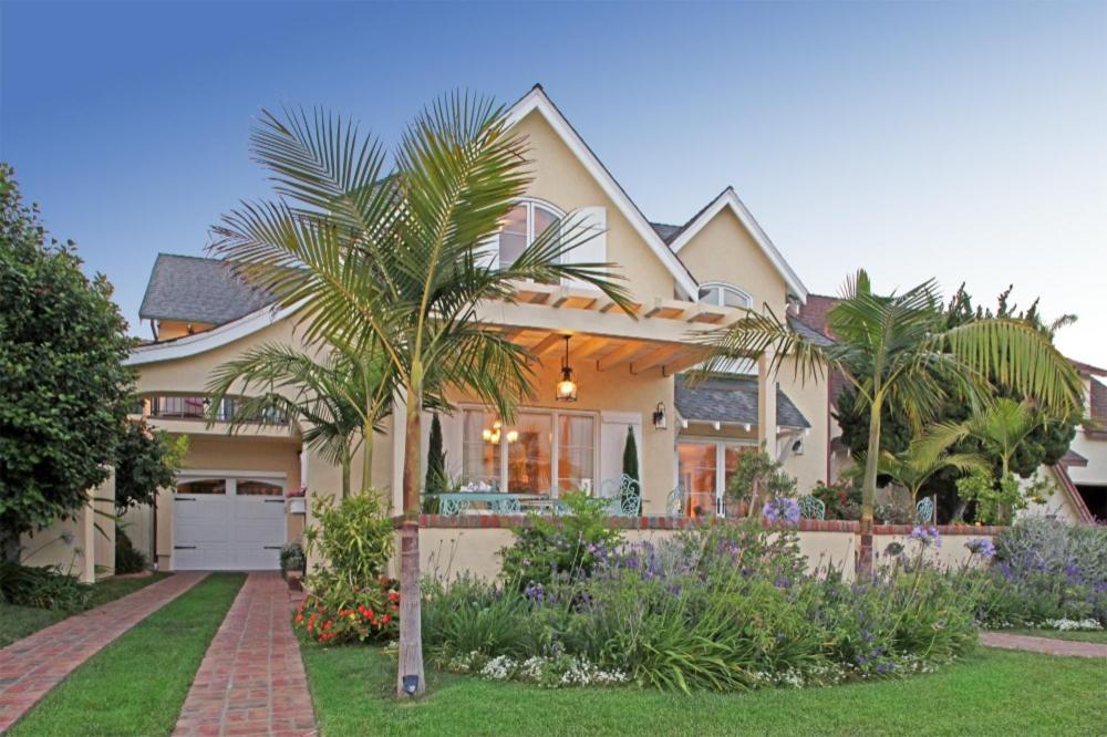 a house with palm trees in the front yard at Coronado Seaside Cottage in San Diego