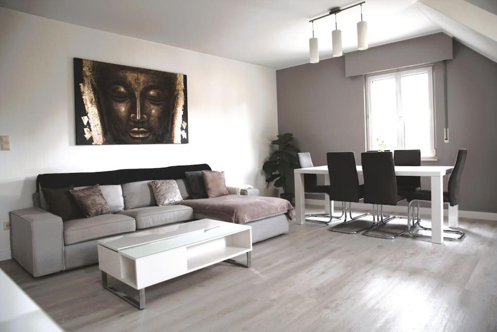 ein Wohnzimmer mit einem Sofa und einem Tisch in der Unterkunft Calm and Cozy apartment Bivange in Livange