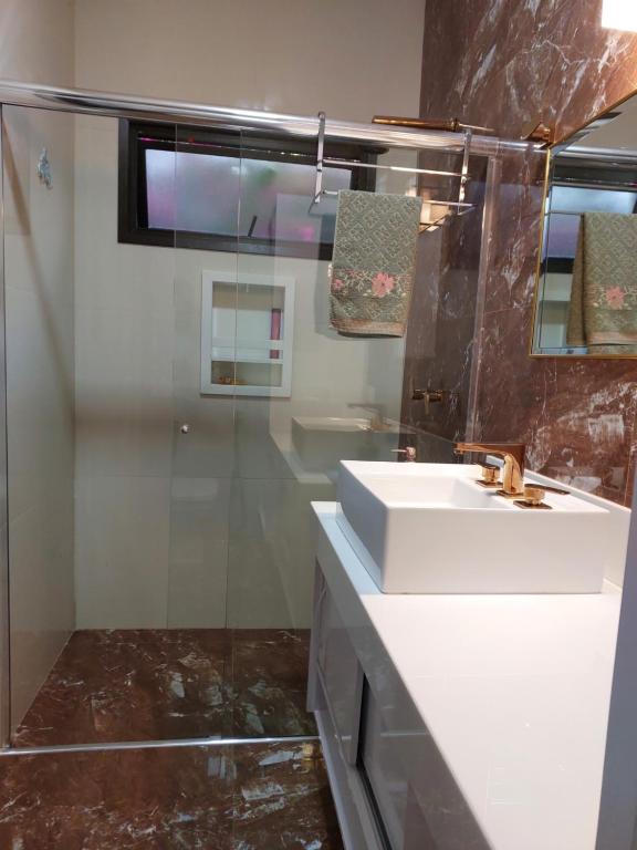 uma casa de banho com um lavatório branco e um chuveiro em Espaço Aconchego em Uberaba