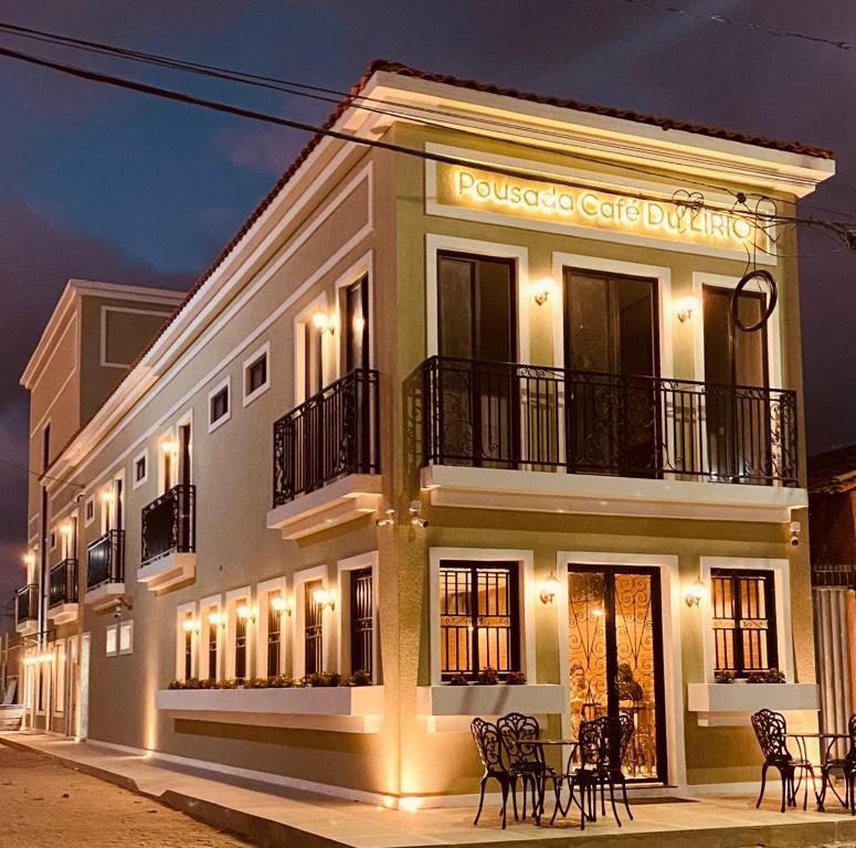 a building with chairs in front of it at night at POUSADA CAFÉ DU'LIRIO in Lagoa Nova