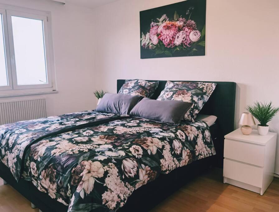 a bedroom with a bed with a floral comforter at Ferienwohnung Sigmaringen in Sigmaringen