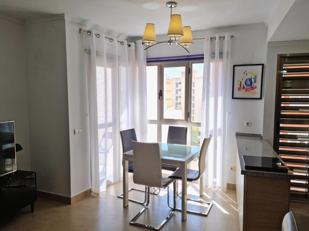 Apartamento Miró في كاليبي: غرفة طعام مع طاولة وكراسي ونافذة