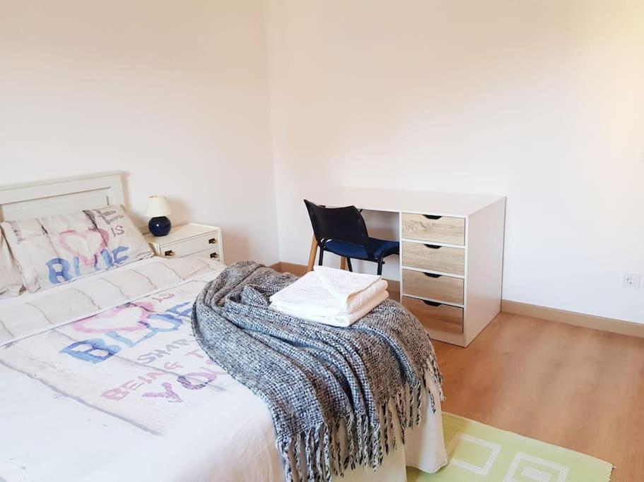 a bedroom with a bed with a chair and a desk at Piso- Huesca Capital - with elevator in Huesca