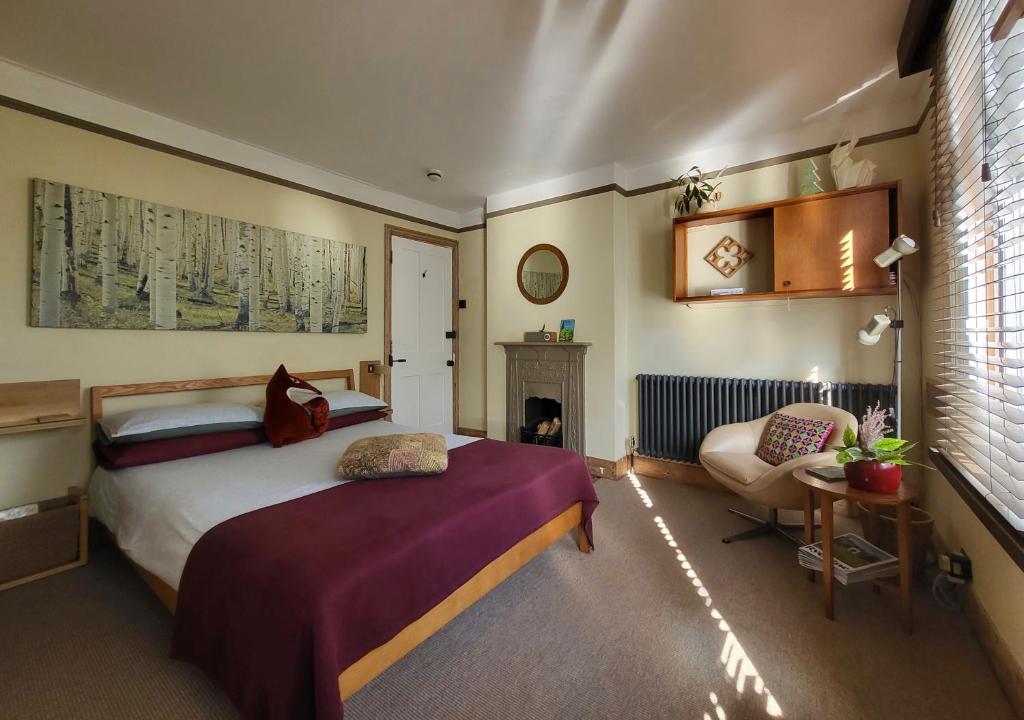 ein Schlafzimmer mit einem Bett und einem Stuhl darin in der Unterkunft Aviemore Rye in Rye