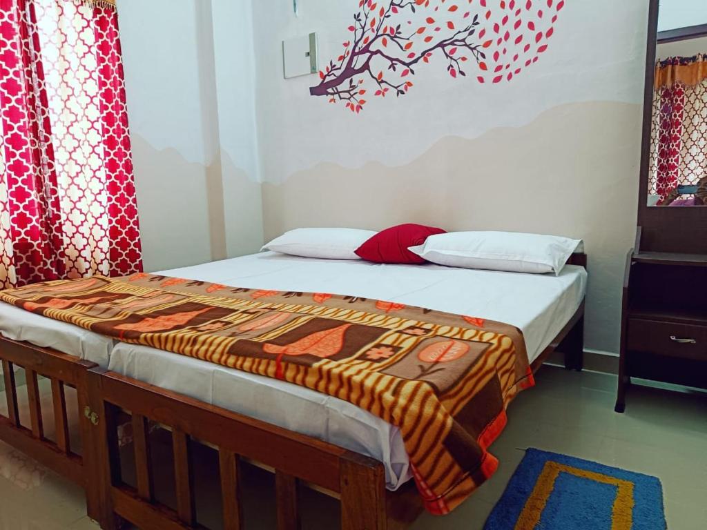 ein Schlafzimmer mit einem Bett mit einer Decke darauf in der Unterkunft Tranquil Meadows Hues in Kattappana
