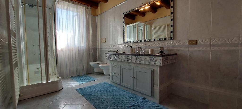 ein Badezimmer mit einem Waschbecken, einem WC und einem Spiegel in der Unterkunft Casa Rosa in Teolo