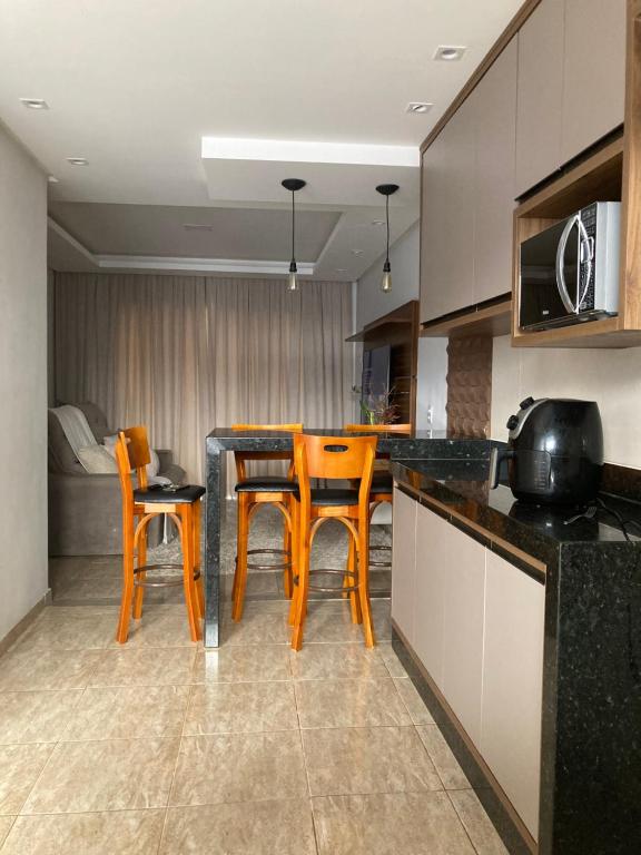 a kitchen with a table and chairs in a room at Casa completa e confortável in Leopoldina