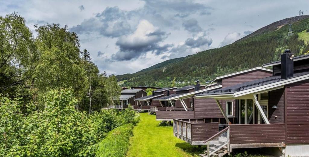 uma fila de alojamentos de madeira nas montanhas em Enjoy MTB downhill, XC, hiking and SPA in Åre 21st to 27th of September em Åre