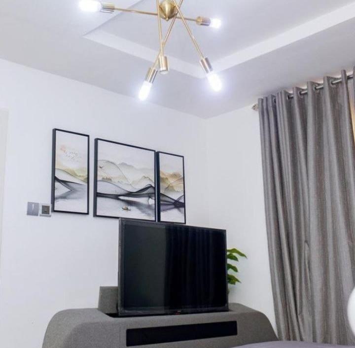 a living room with a flat screen tv on a table at Gilpins Classic Penthouse in Lekki