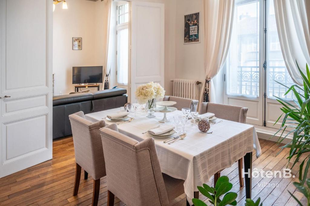 een eetkamer met een tafel en stoelen bij "Les Effrontés" Louis Blanc Charming Apartment in Limoges