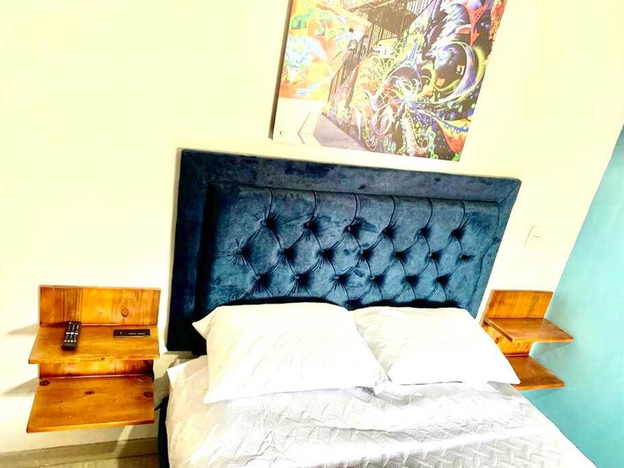 - une chambre avec un lit doté d'une tête de lit bleue dans l'établissement Grafiti Love, à Sabaneta