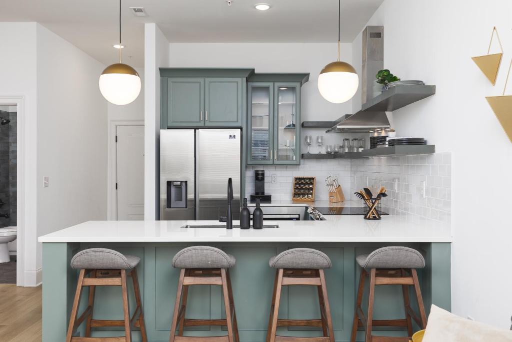 ナッシュビルにあるLuxury Design, Close to Broadway - 4 Beds, 2 Bedrmのキッチン(青いキャビネット、バースツール付)