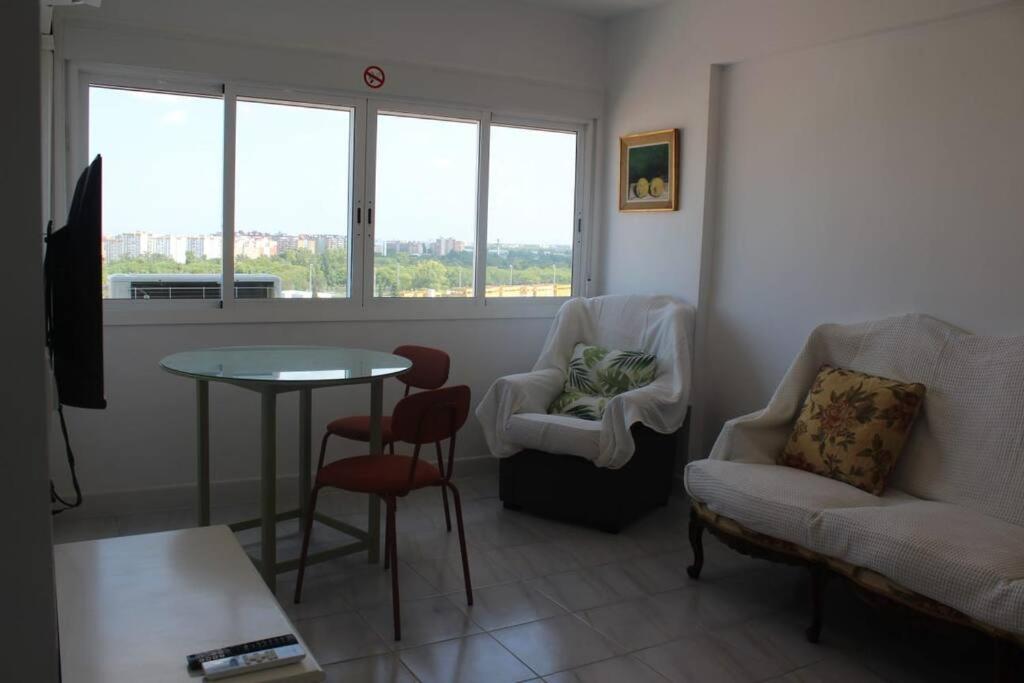 sala de estar con sofá, mesa y sillas en ROCH2 - Modern Apartment near Metro, en Sevilla