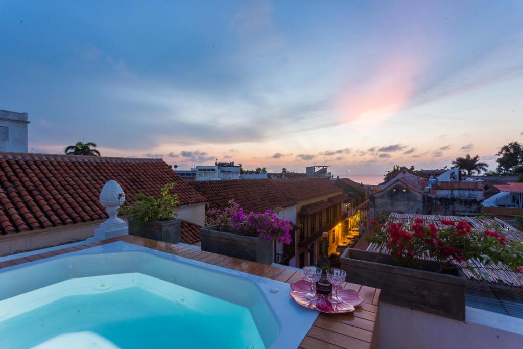 - une piscine sur le toit d'une maison avec un coucher de soleil dans l'établissement Al Alma Apart-Suites, à Carthagène des Indes