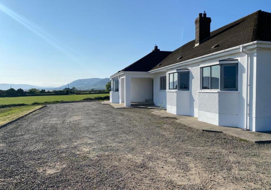 a white house with a gravel driveway at Millbay View House in Kilkeel